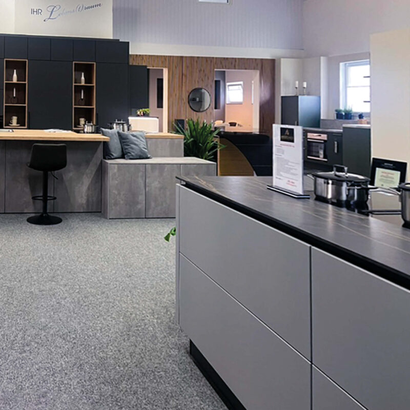 Moderne Küchen in Grau mit Holzarbeitslatten und schwarzen Akzenten.