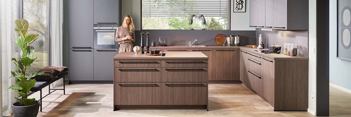 Moderne Küche mit Kücheninsel in Holzfronten und Arbeitsfläche aus Holz. Hängeschränke mit grauen Fronten.