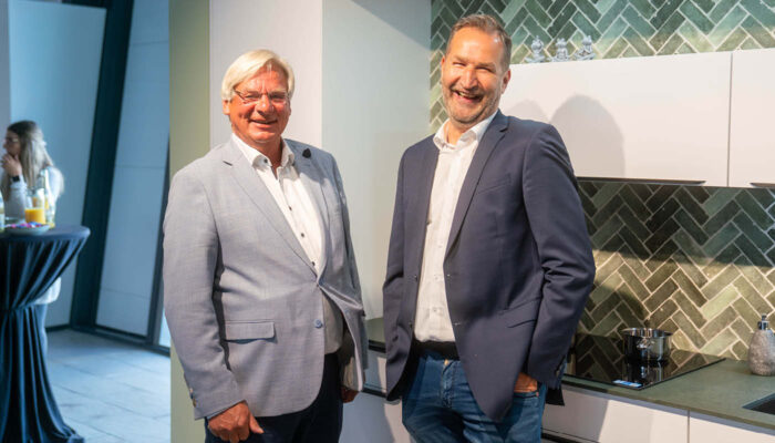Zwei Personen lächeln bei der Neueröffnung von Schulers Küchenstudio