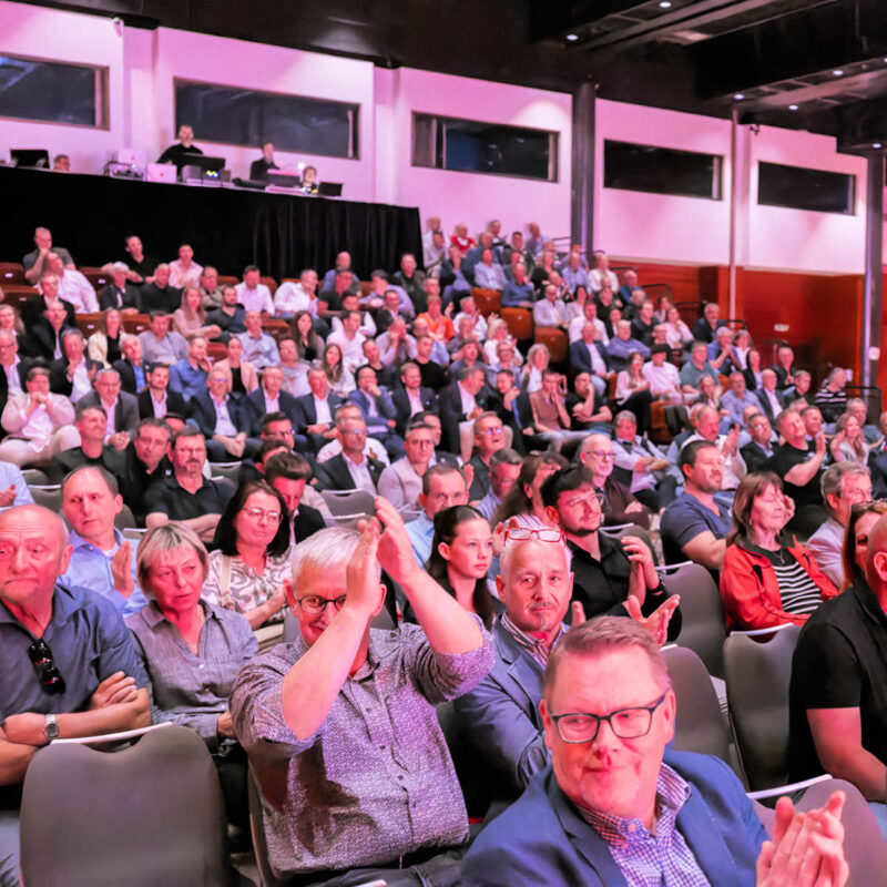 Ein voller Saal mit vielen Menschen.