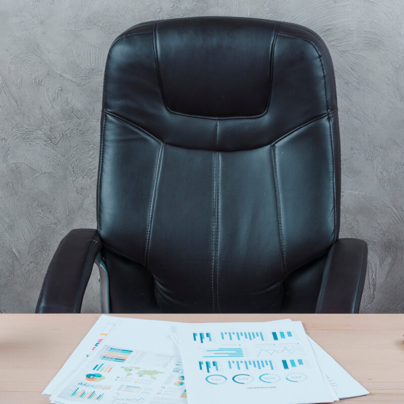 Leerer Bürostuhl mit Unterlagen auf dem Schreibtisch – Symbol für eine offene Position