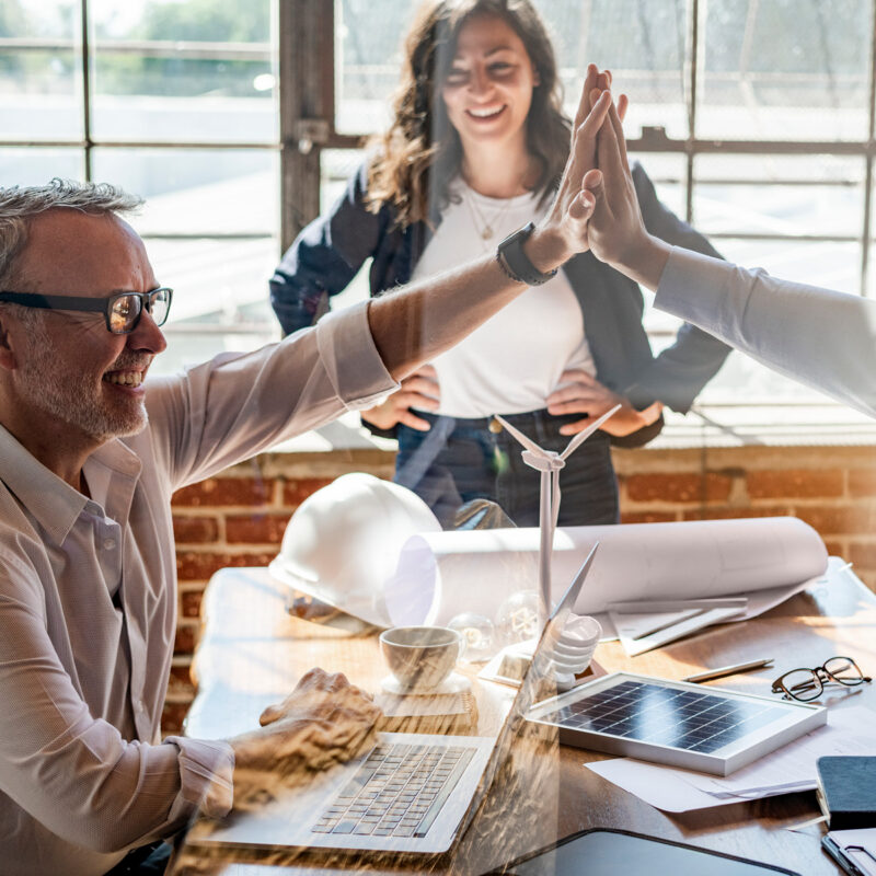 Team feiert gemeinsamen Erfolg im Büro – Symbol für Teamgeist und Zusammenarbeit