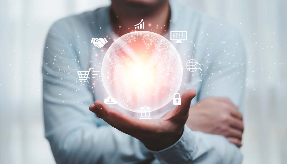 Mann hält holografische Weltkugel mit digitalen Symbolen – Darstellung für globale Vernetzung und technologische Innovation.