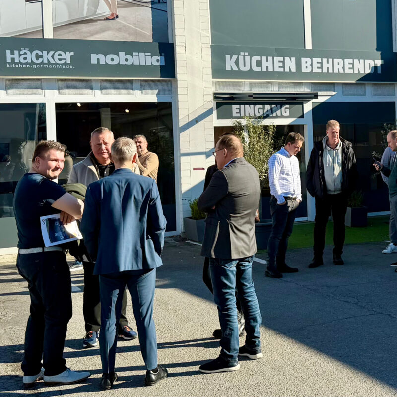 Mehrere Personen stehen vor dem Küchenstudio Behrendt und unterhalten sich in kleinen Gruppen