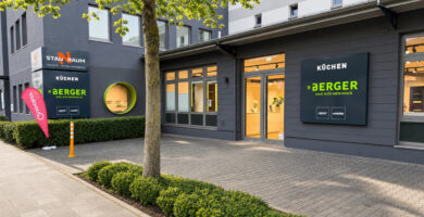 Modernes Küchenstudio Berger Das Küchenhaus in Duisburg mit gepflegter Außenansicht, großen Schaufenstern und beleuchtetem Eingangsbereich bei freundlichem Tageslicht.
