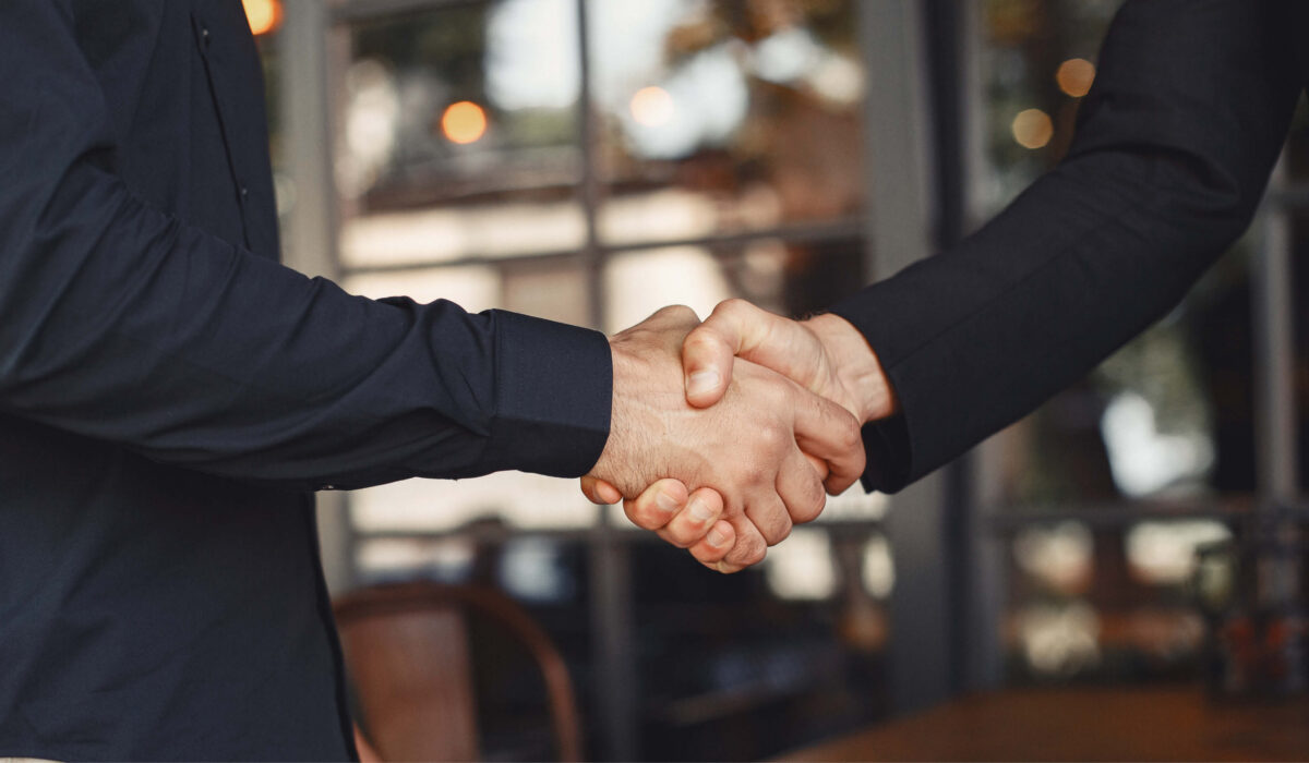 Zwei Geschäftspartner besiegeln eine Zusammenarbeit mit einem Handschlag