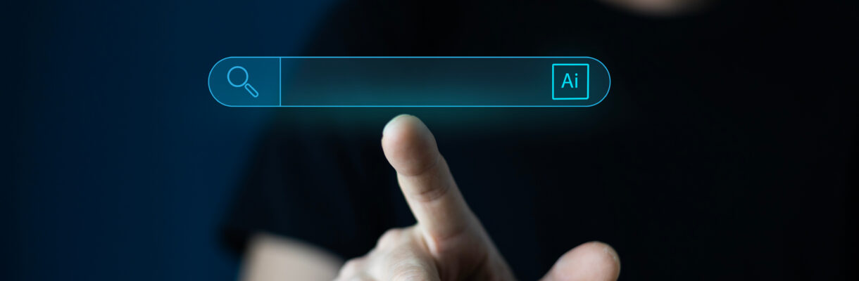 KI-Suche: Person bedient digitale Suchleiste mit KI-Symbol auf einem Bildschirm.