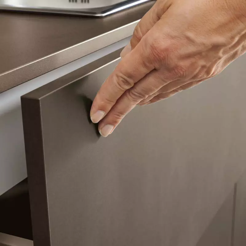 Eine Hand die über eine glatte Küchenoberfläche streicht.