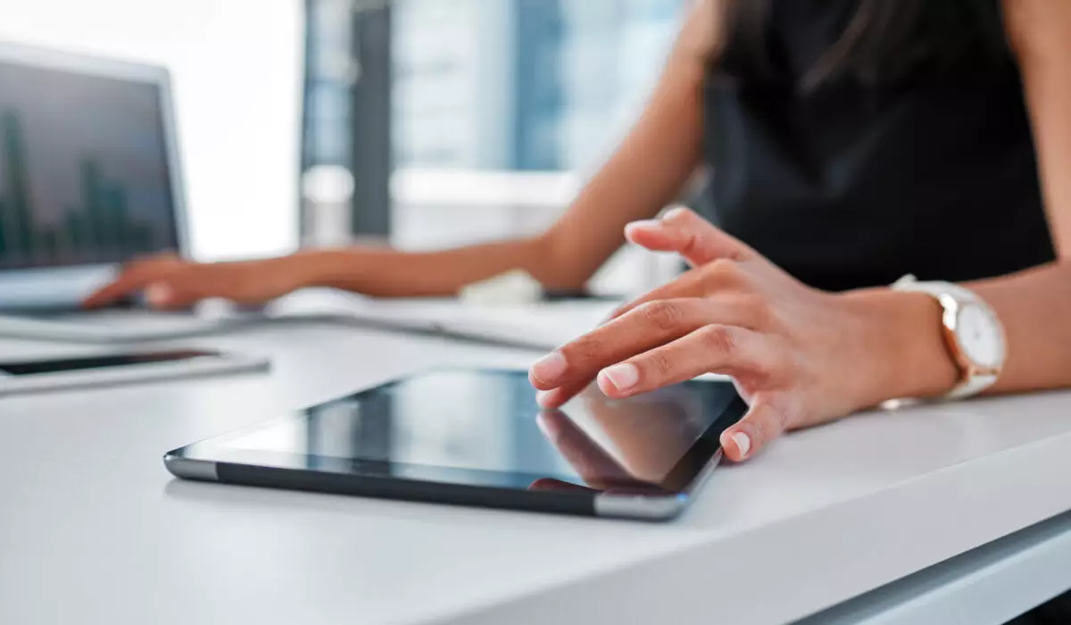 Frau arbeitet am Tablet und Laptop – digitale Lösungen und Tools für Küchenhändler von Der Küchenring.
