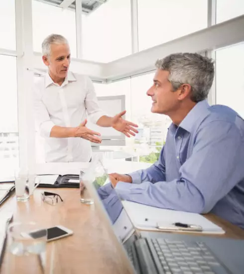 Zwei Männer im Gespräch während einer Besprechung – Austausch und Zusammenarbeit in professioneller Atmosphäre.