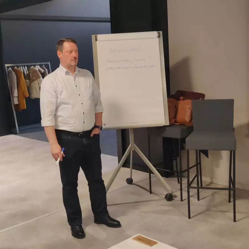 Ein Mann steht vor einem Flipchart und präsentiert etwas