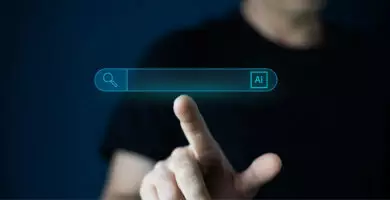KI-Suche: Person bedient digitale Suchleiste mit KI-Symbol auf einem Bildschirm.