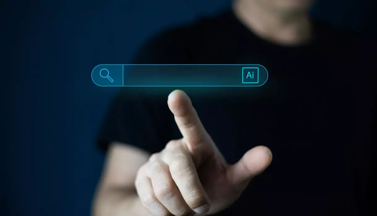 KI-Suche: Person bedient digitale Suchleiste mit KI-Symbol auf einem Bildschirm.